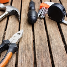 assorted-type carpentry tools on brown surface