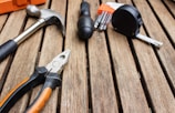 assorted-type carpentry tools on brown surface