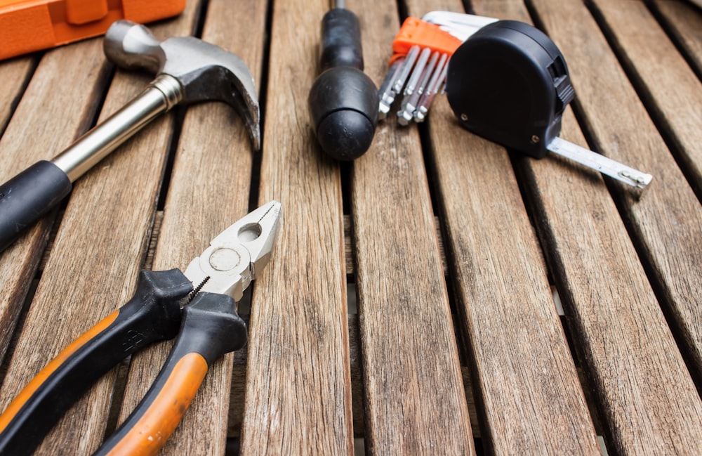 assorted-type carpentry tools on brown surface