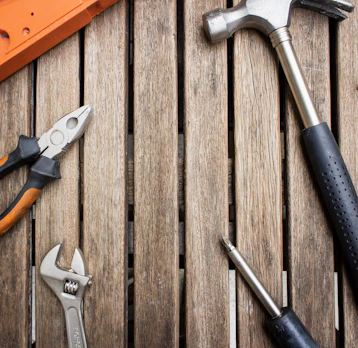 Set of durable hand tools including hammers and screwdrivers on a wooden surface.