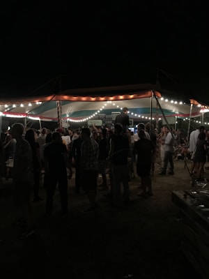 People gathered at an outdoor event under string lights.