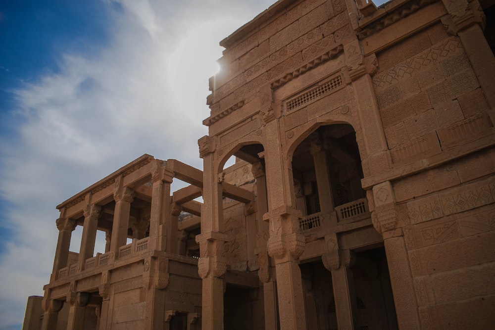 low-angle photography of brown pillared building during daytime