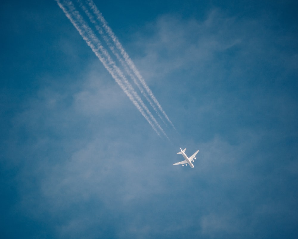 white airplane leaving trails photo