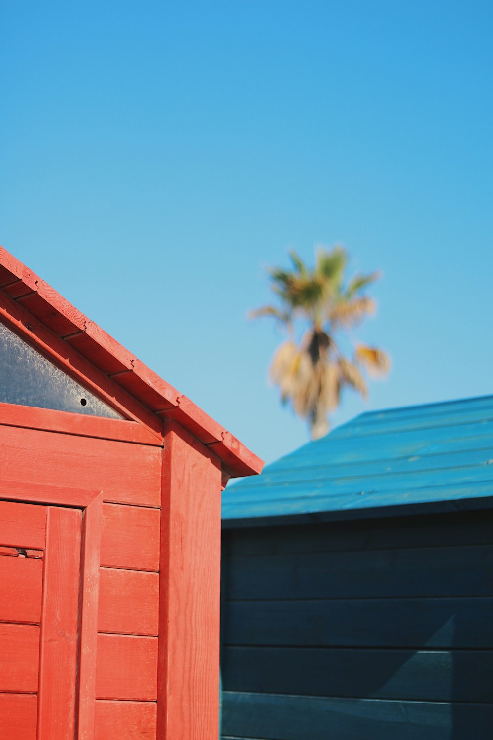 red and blue wooden sheds under blue sky