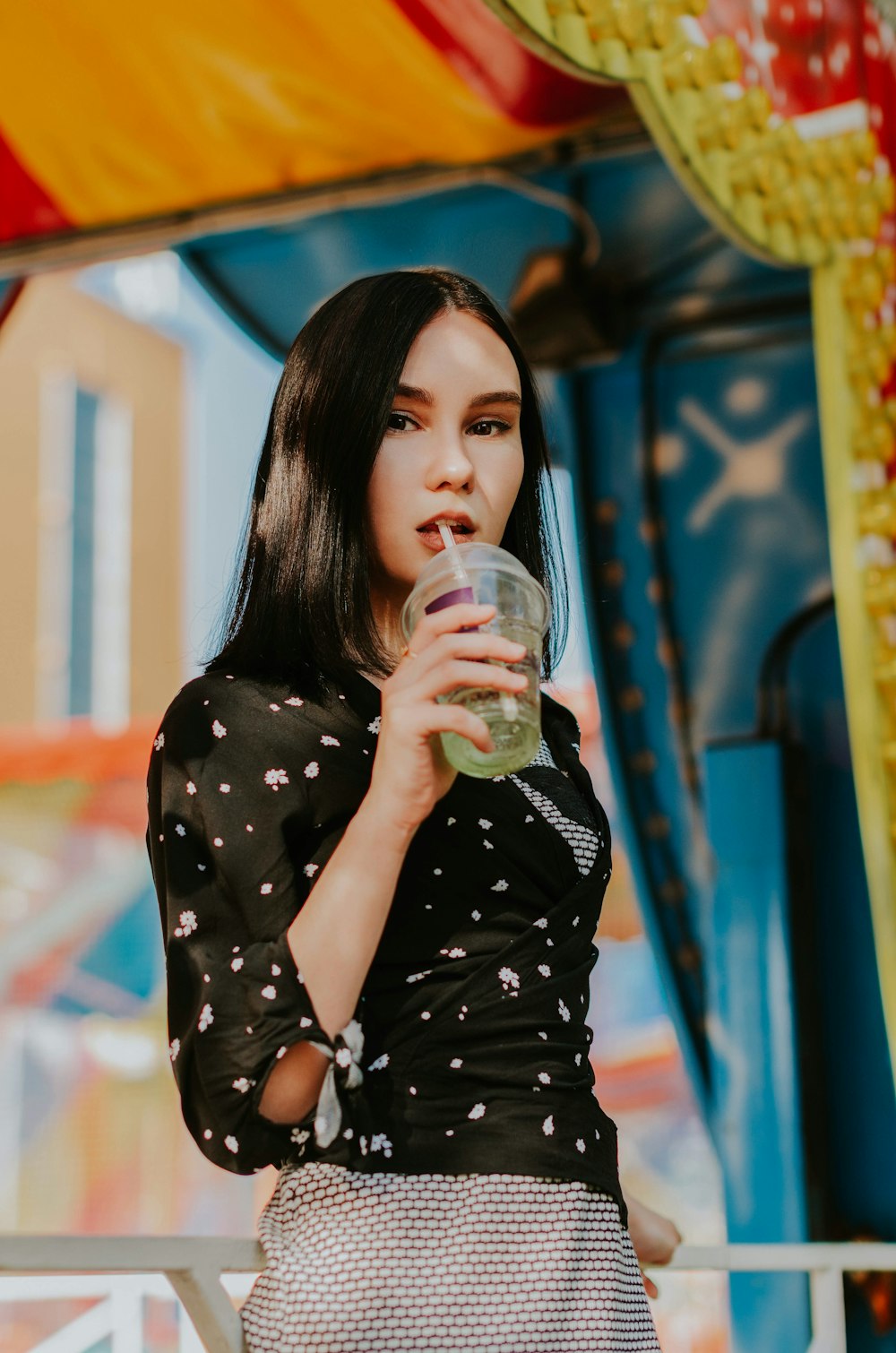 woman wearing black and white top drinking on clear plastic cup