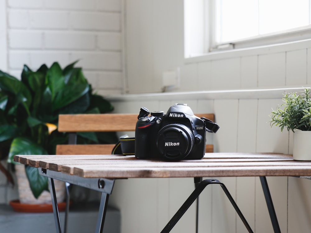 black Nikon DSLR camera on table