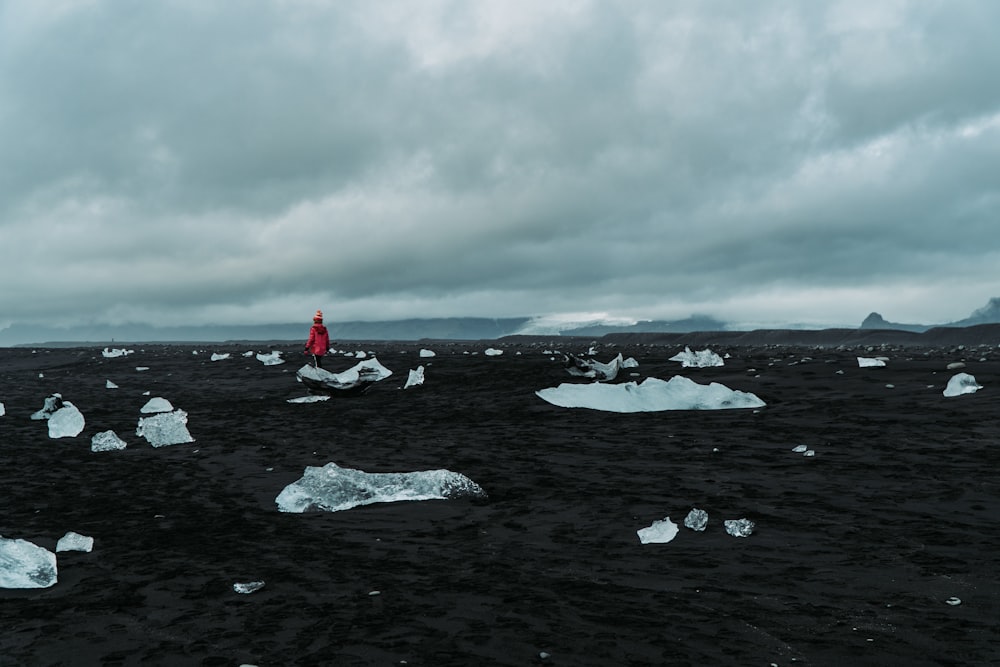 person wearing red top across horizon during cloudy daytime