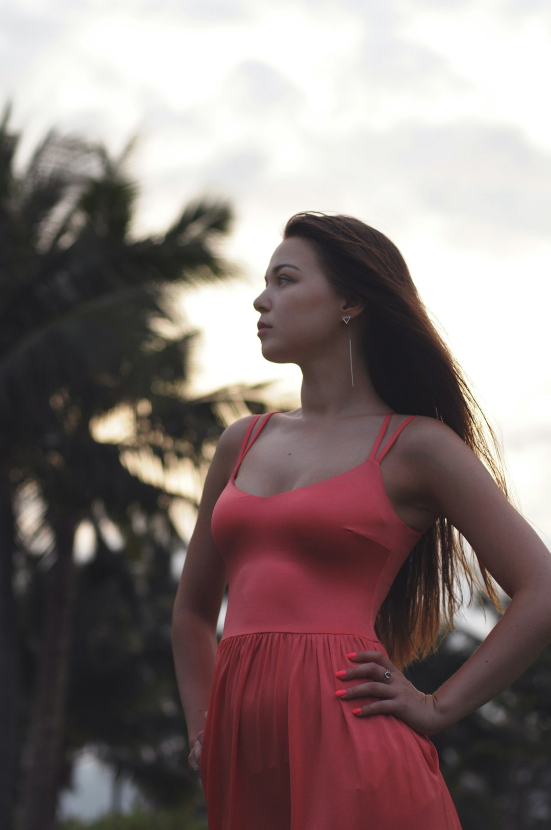 standing woman wearing red spaghetti strap dress