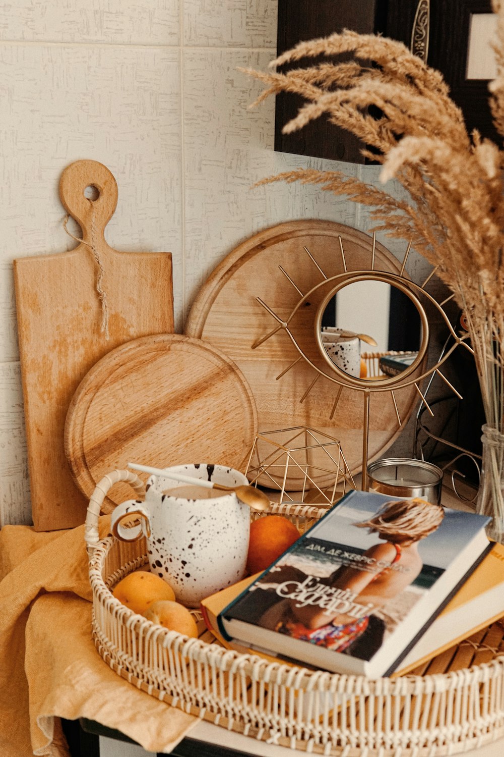 books and white ceramic mug on wicker serving tray