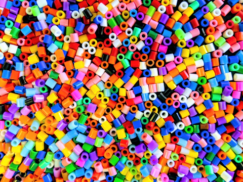 Close-up of colorful plastic resin pellets in a factory setting