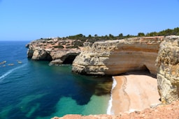 brown cliff beside body of water during daytime photo