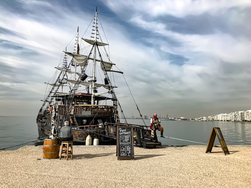 man sitting on ship during daytime