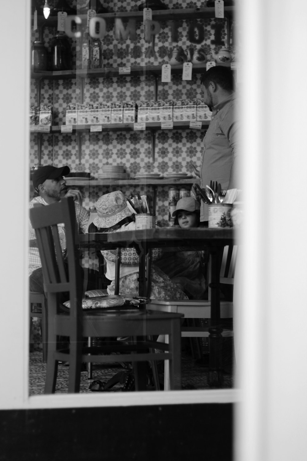 Foto en escala de grises de un hombre con polo y mesa marrón
