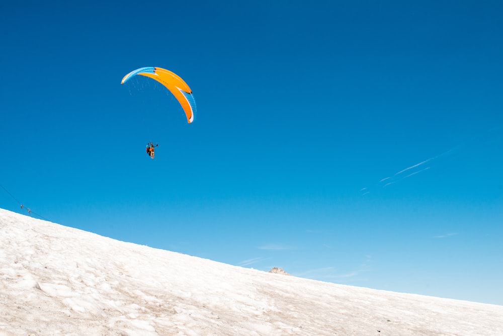 person paragliding in midair during daytime