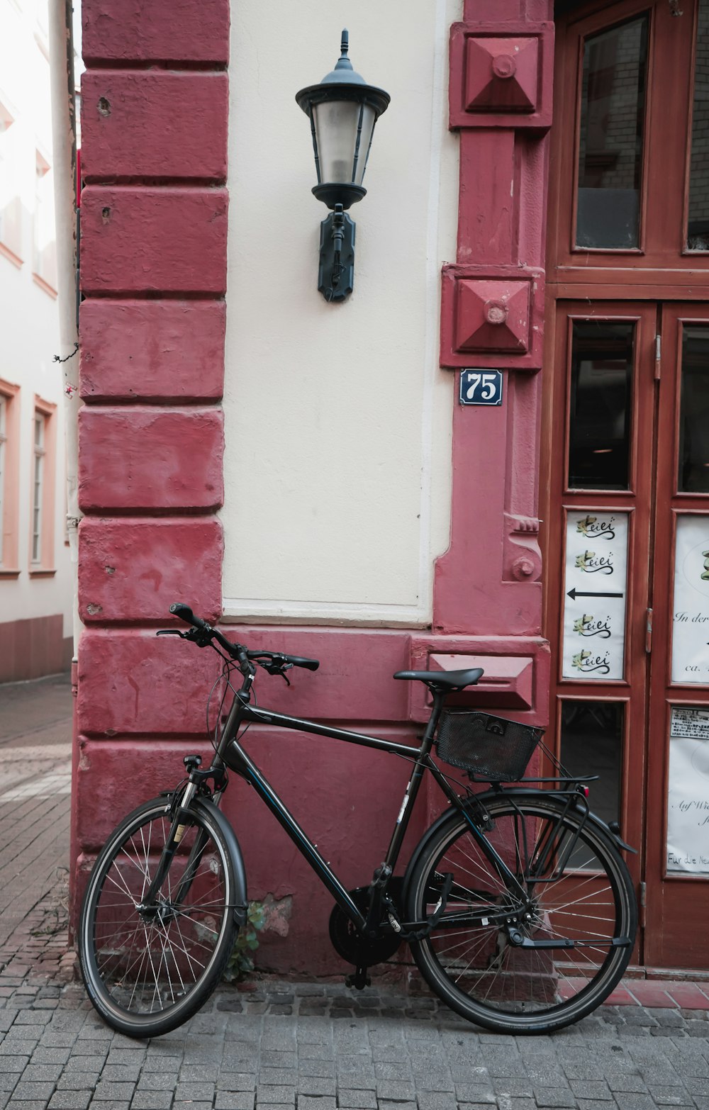 black bicycle leaning on wall