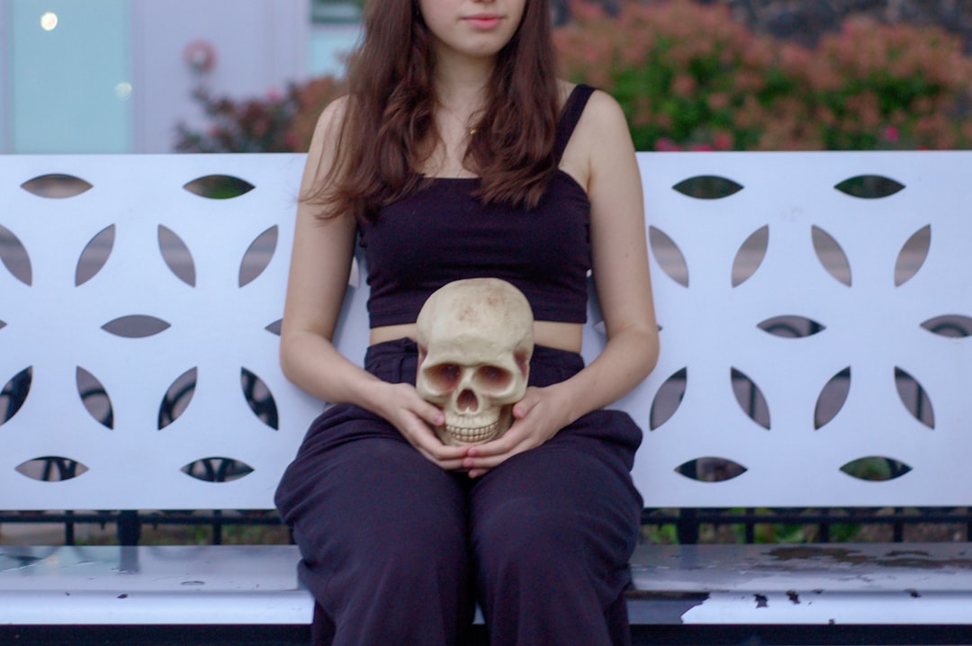 woman holding skull sitting on bench