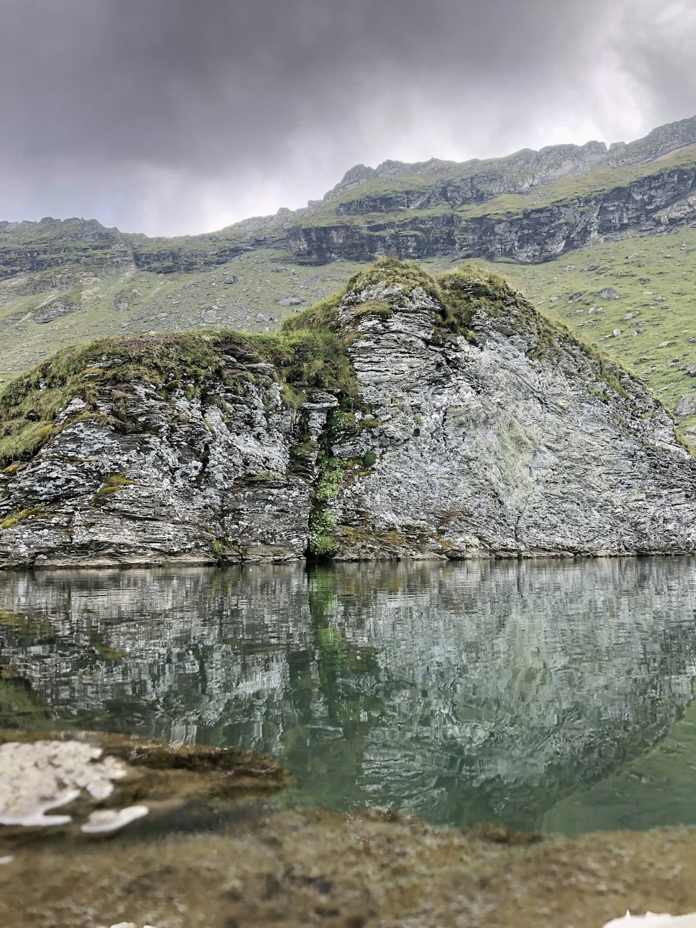 grey cliff beside calm body of water