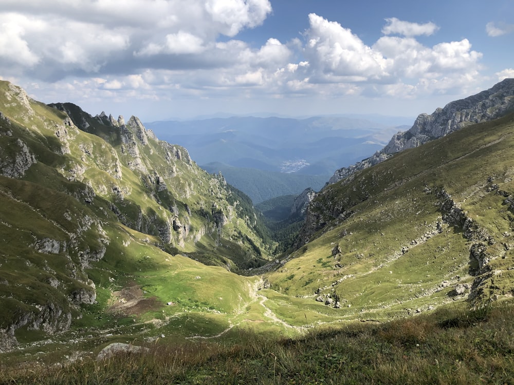 green covered mountains under white clouds