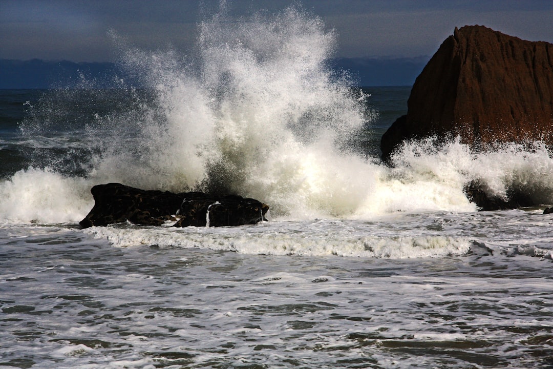 Spray and foam is tossed high in the air when a wave smashes into a rock as the tide comes in.