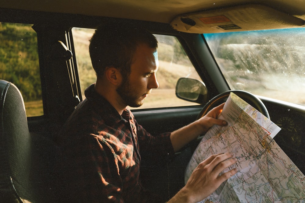 man riding on vehicle looking for map