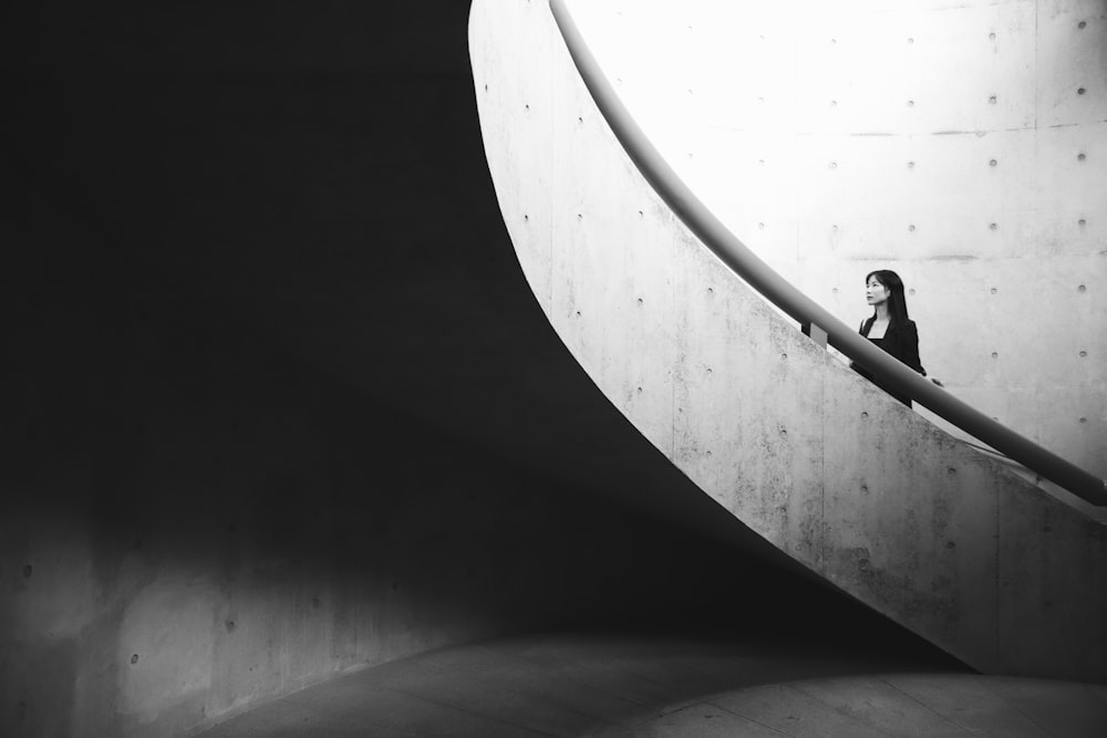 a woman is standing on the edge of a wall