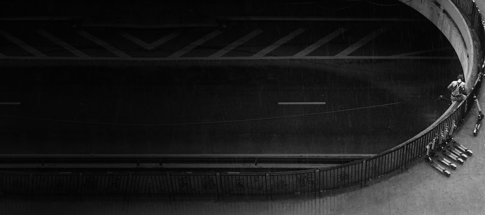 grayscale photography of scooters beside balustrade on bridge