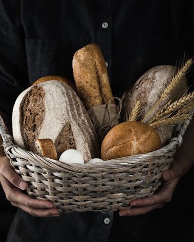 A rustic basket filled with eggs, fresh bread, and farm-picked herbs.
