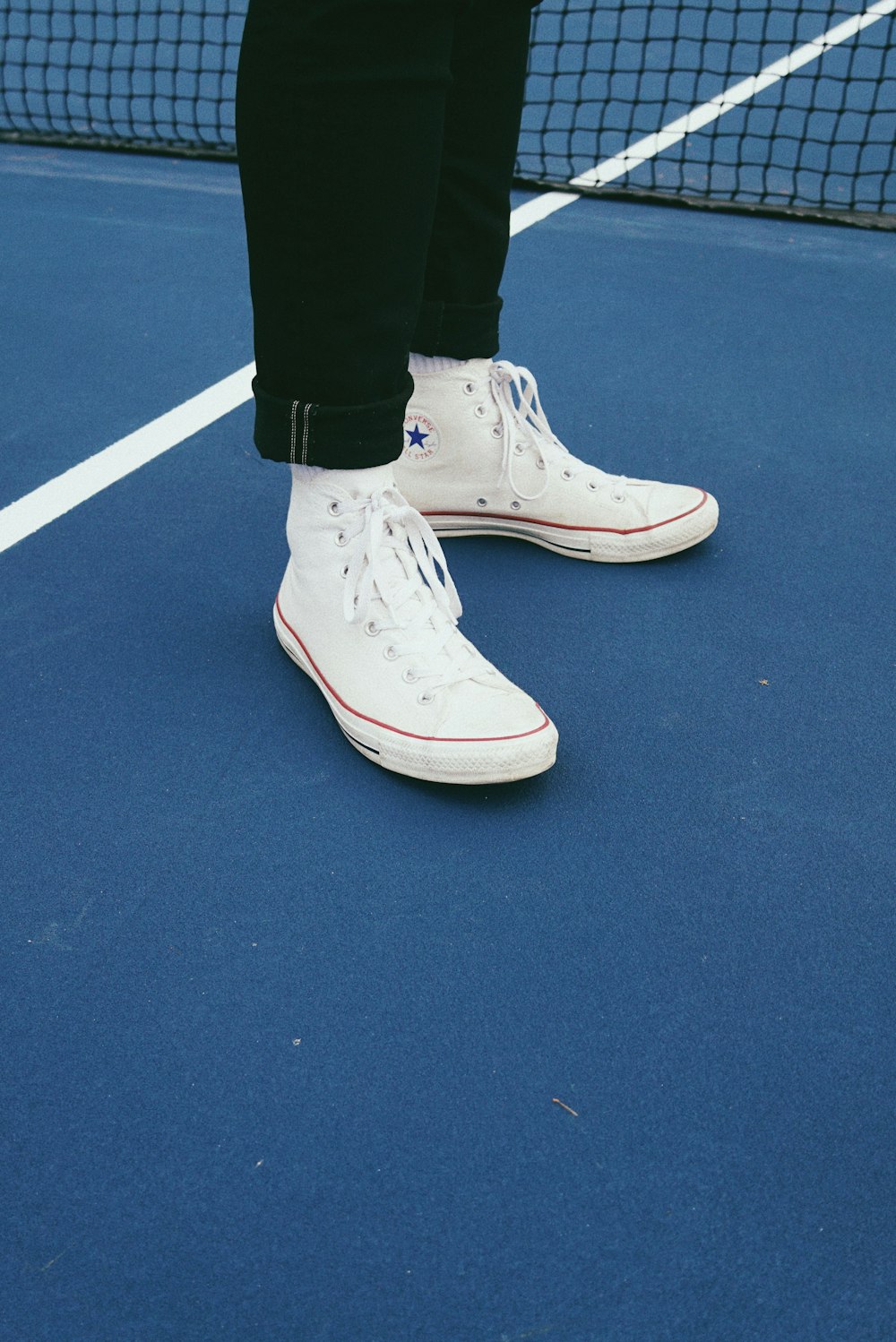 person in white Converse All-Star high-top sneakers