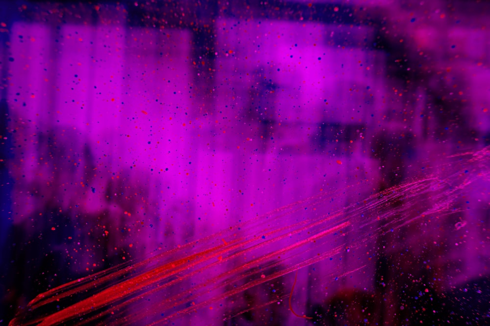 Ein verschwommenes Bild eines Gebäudes mit violetten und roten Lichtern