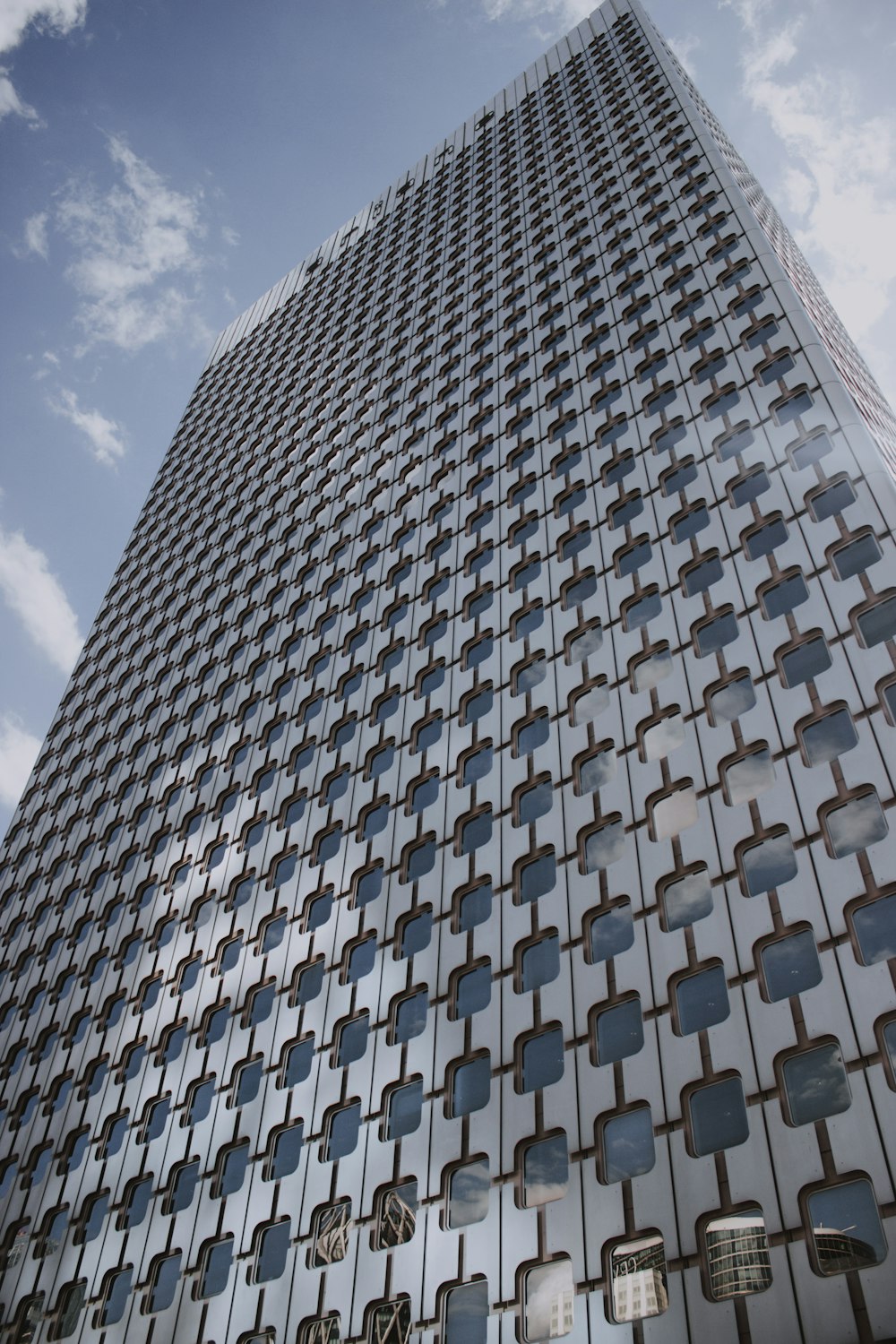 low-angle photography of high-rise building under blue and white skies during daytime