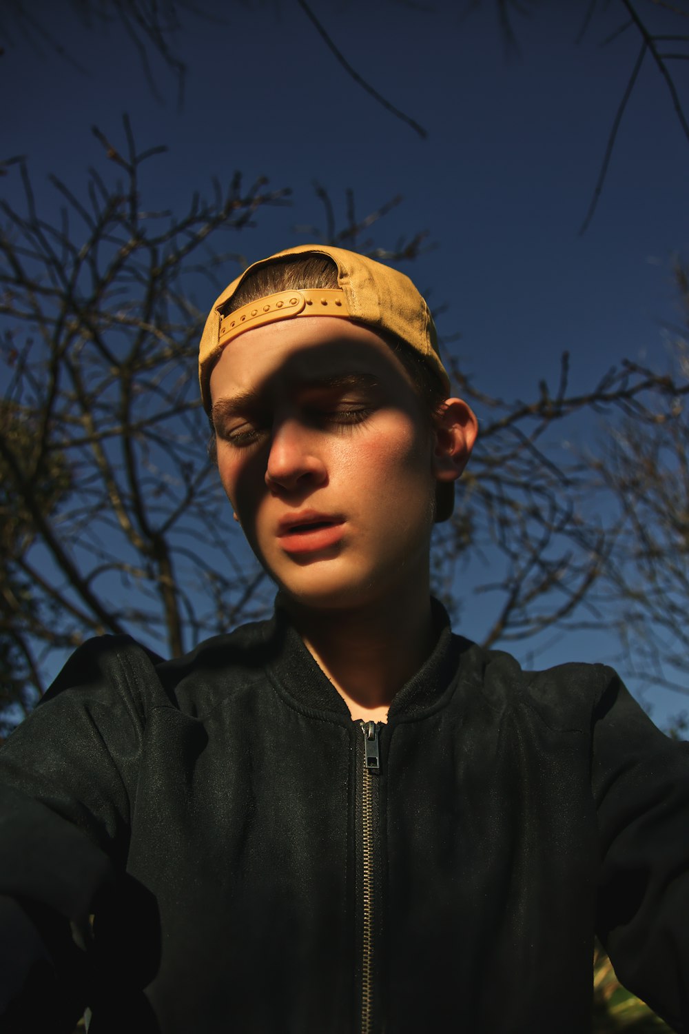 man wearing black zip-up jacket and brown hat