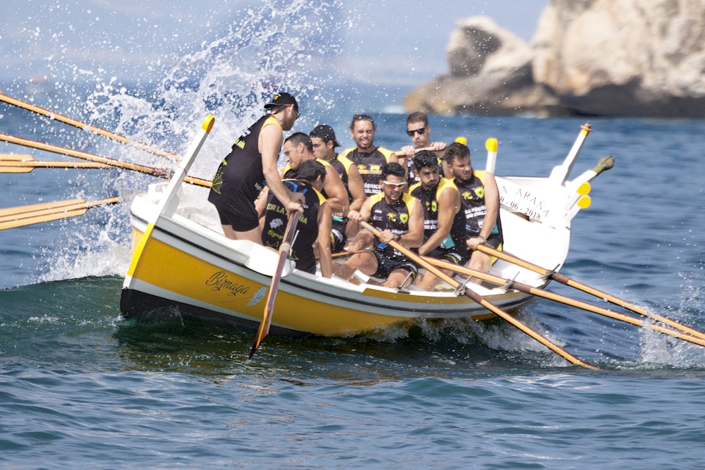 group of men in boat on blue sea during daytime