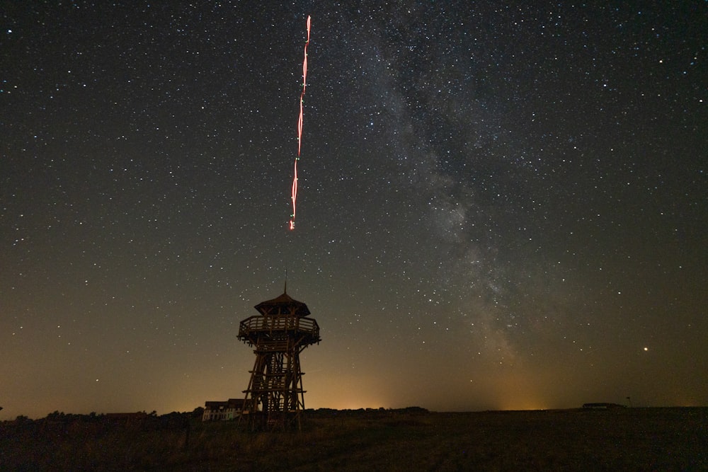 silhouette of tower under starry sky