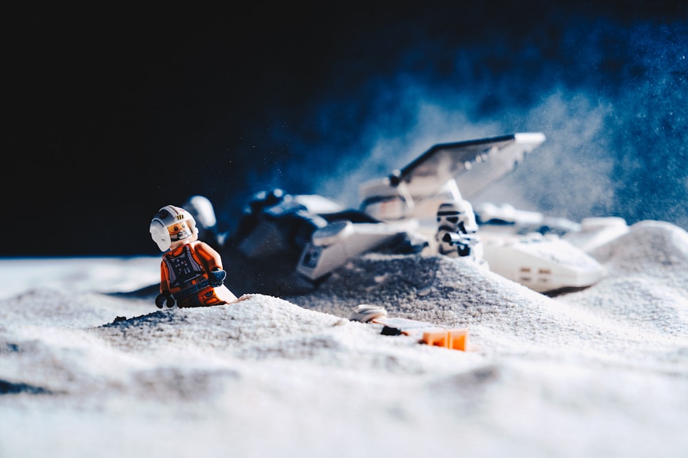 astronaut beside spaceship on gray sand