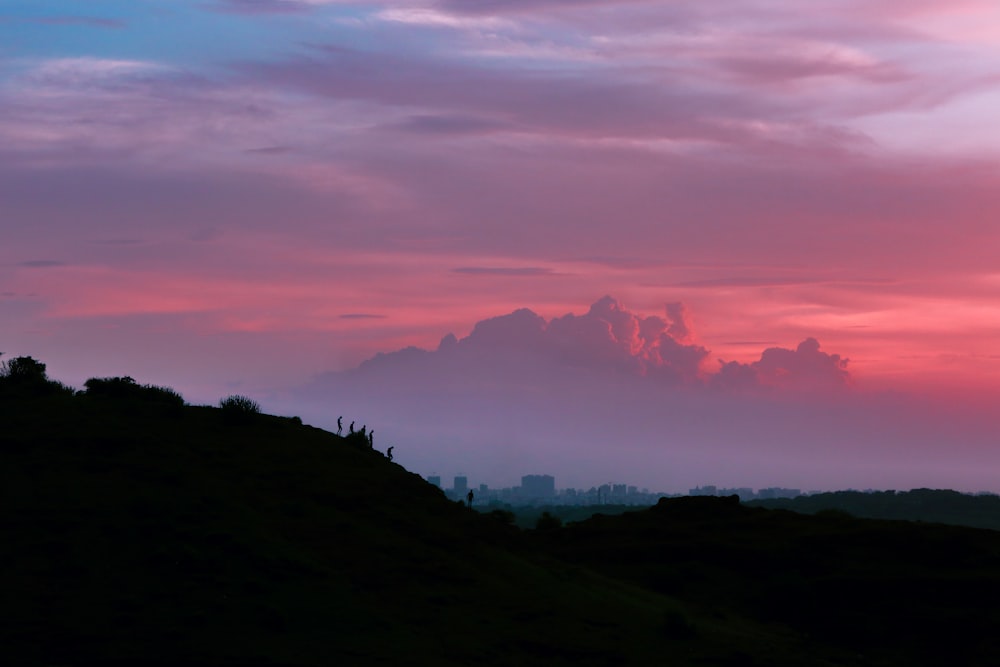 silhouette of mountain under cloudy sky during golden hour