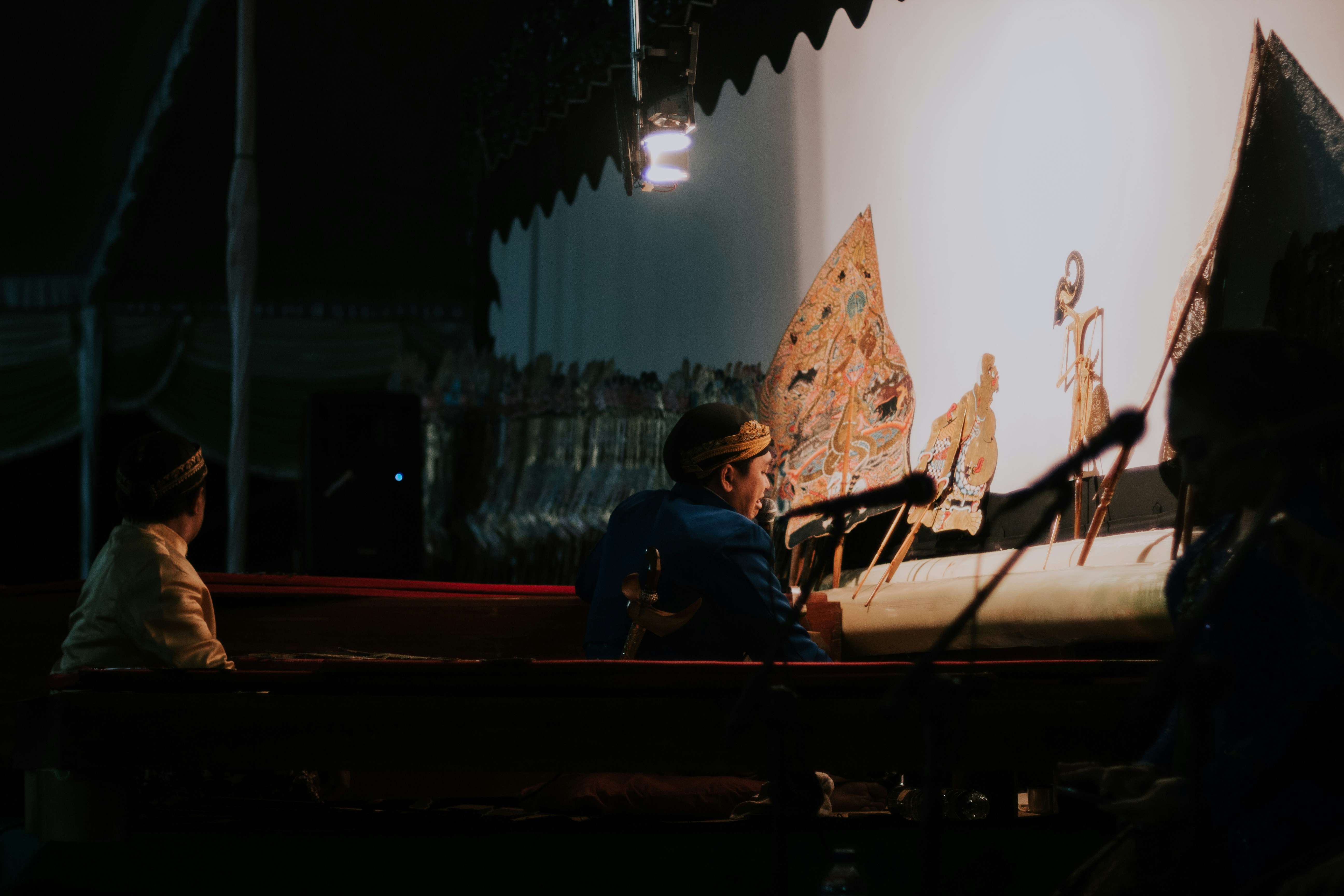 uomo che tiene il microfono davanti al palco