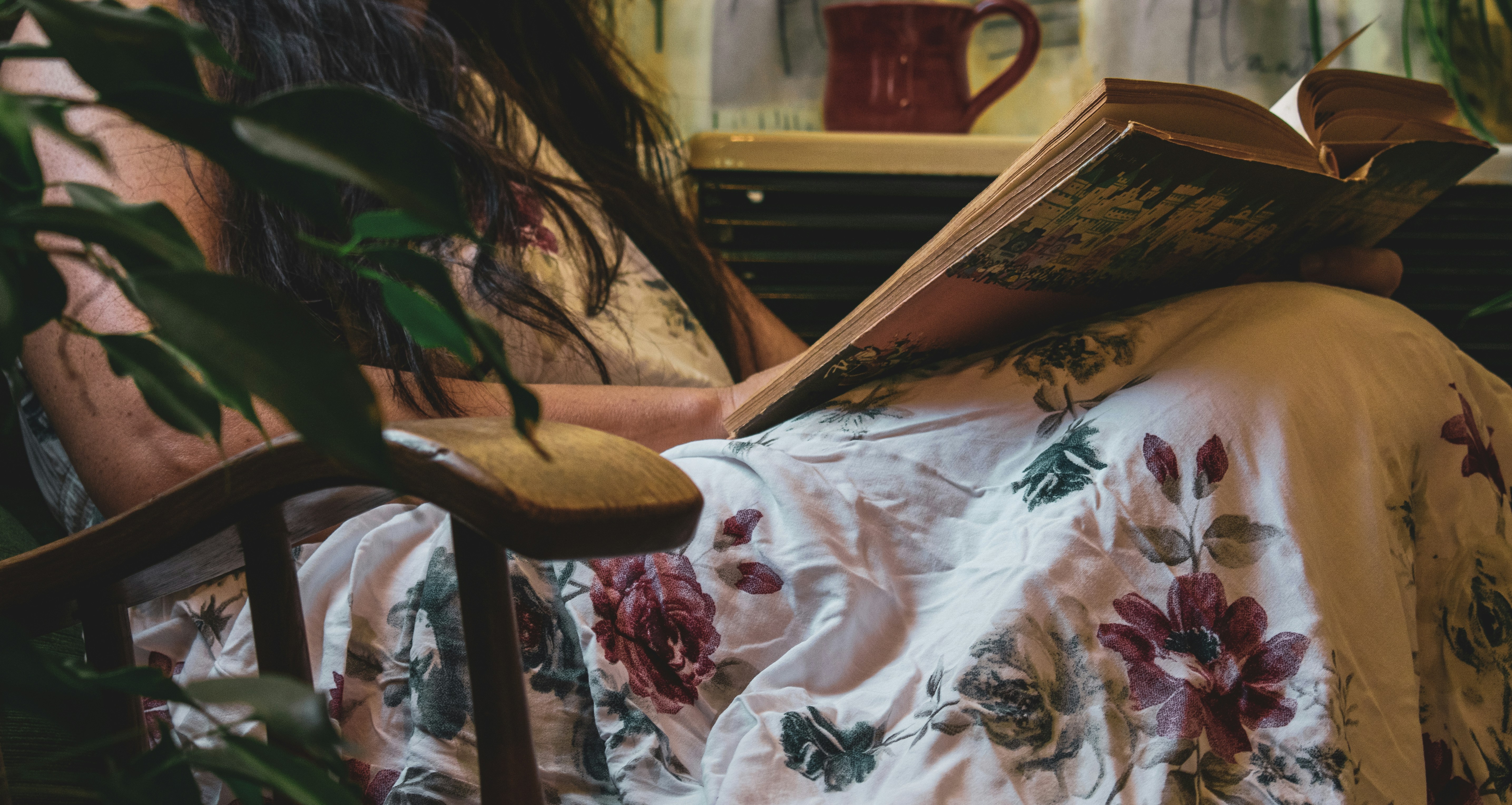 woman sitting on chair while reading book