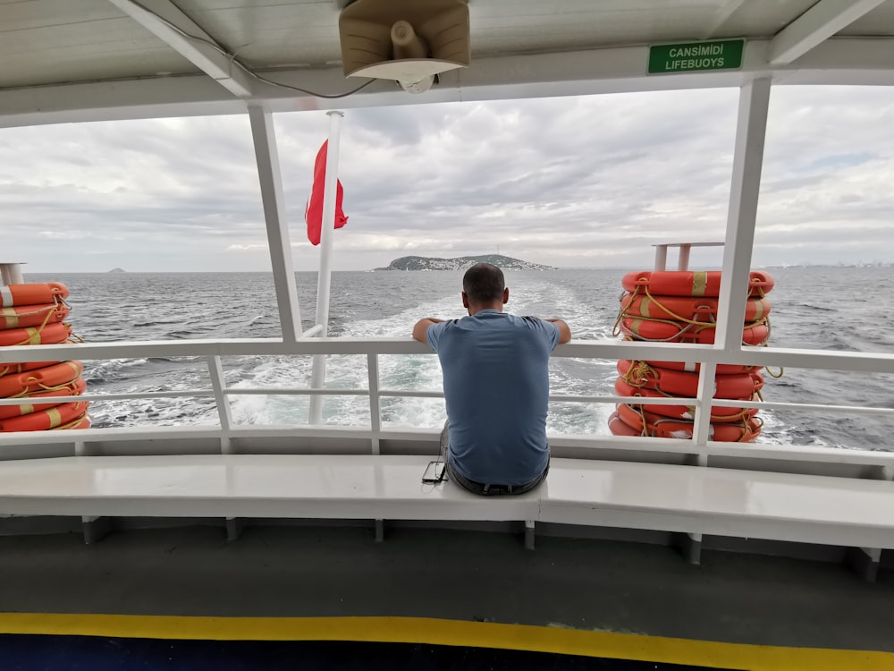 a man sitting on a boat looking out at the ocean