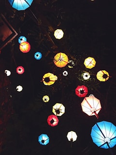 Lea, Ben and Lumi looking at colorful lanterns during a festive night celebration.