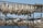 Wooden racks display numerous fish being air-dried, set against a backdrop of a small coastal town with a mountainous landscape in the distance. The scene includes a variety of houses and buildings near a rocky waterfront.