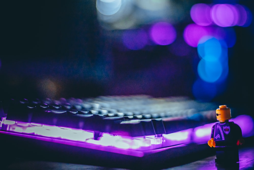 a lego man standing in front of a computer keyboard