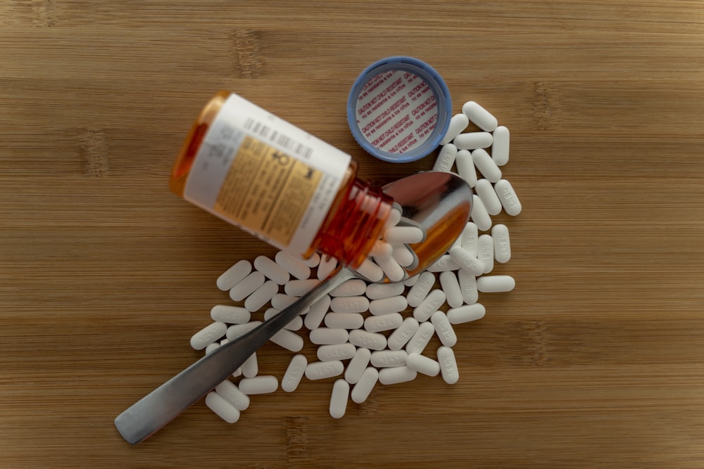 oval white medication pills on brown wooden surface