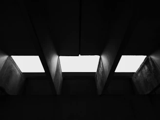 A stark black-and-white photo of Kinshasa's concrete architecture with sharp geometric lines.