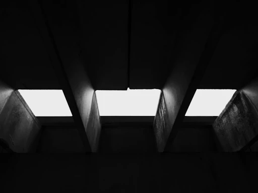 A stark black-and-white photo of Kinshasa's concrete architecture with sharp geometric lines.