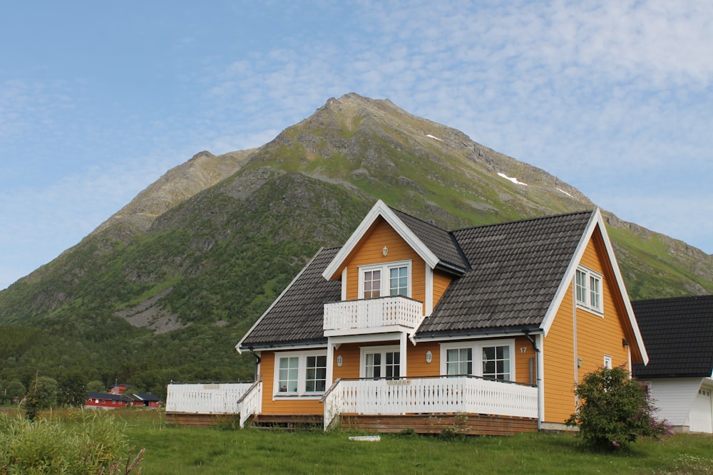 house on grass near mountain during day