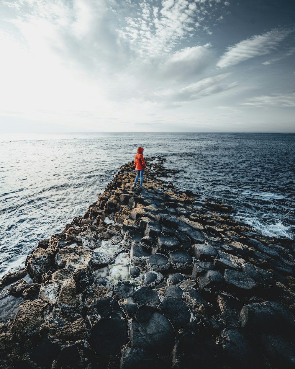 a person standing on the edge of a pier near the ocean