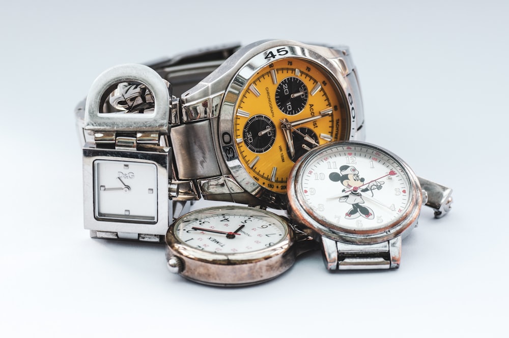 three silver-colored watches