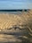 brown sand beside body of water at daytime