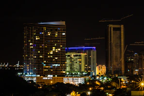 A nighttime cityscape showcasing illuminated buildings developed through Midios International’s projects, reflecting growth and innovation.