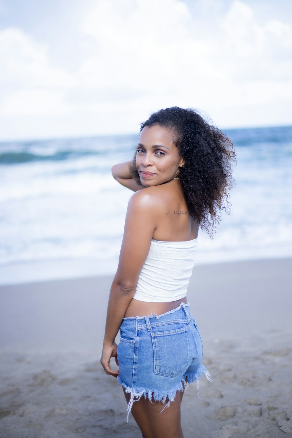 top branco de decote branco feminino e shorts jeans azuis